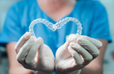 dentist holding up clear aligners