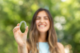 woman smiling holding clear aligners after learning the benefits of at home clear aligners vs in office