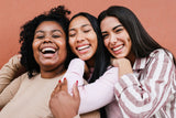 Three women smiling, showing the beautiful smile you can maintain with the right dental retainer types.
