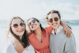 three women smiling with sunglasses possibly enjoying the benefits of orthodontic innovation