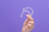 hand holding up clear aligners