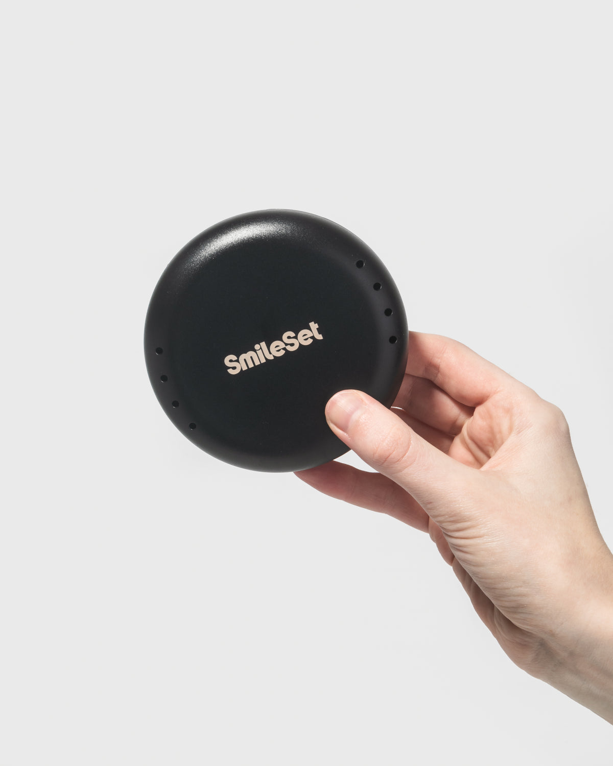 Hand holding a black SmileSet retainer case