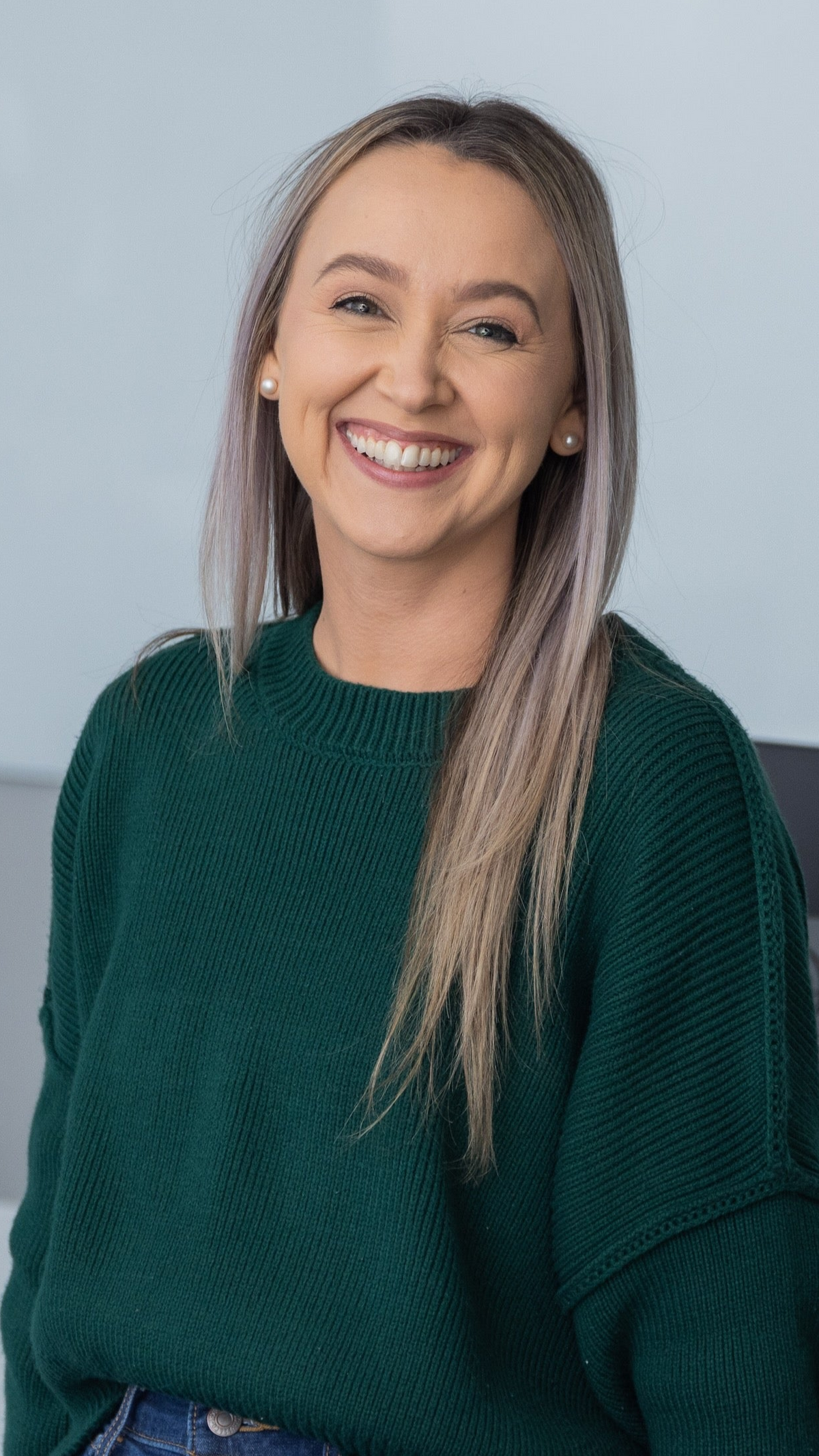 Woman in a green sweater standing in an office setting