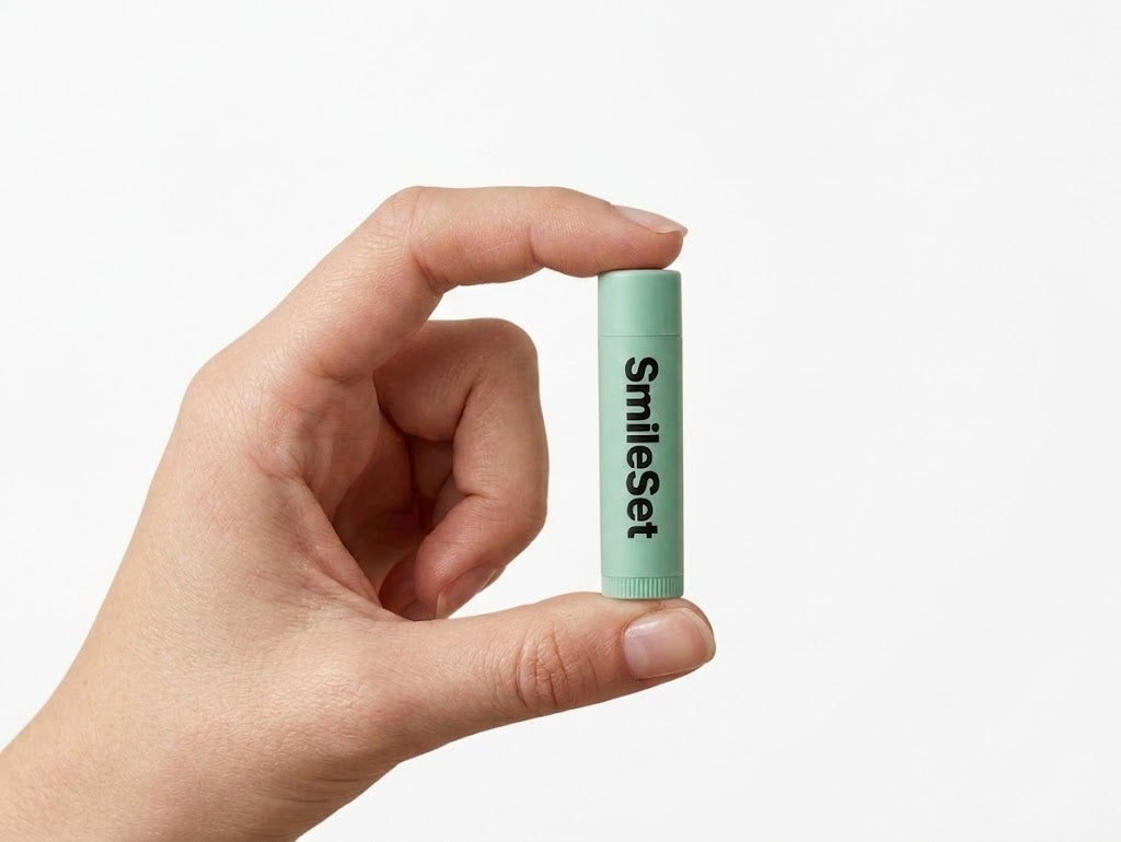 Hand holding a mint SmileSet twist-up lip balm