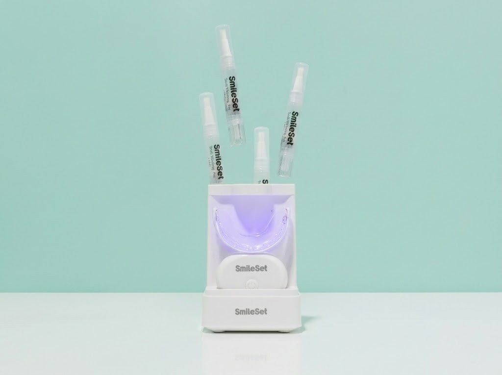SmileSet LED whitening tray with whitening pens on a mint background