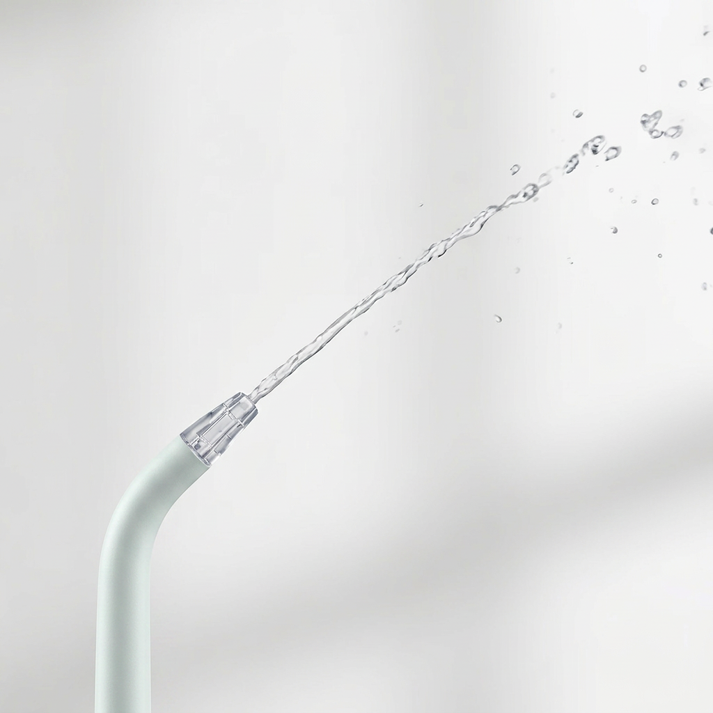 Close-up of a water flosser tip spraying a stream of water