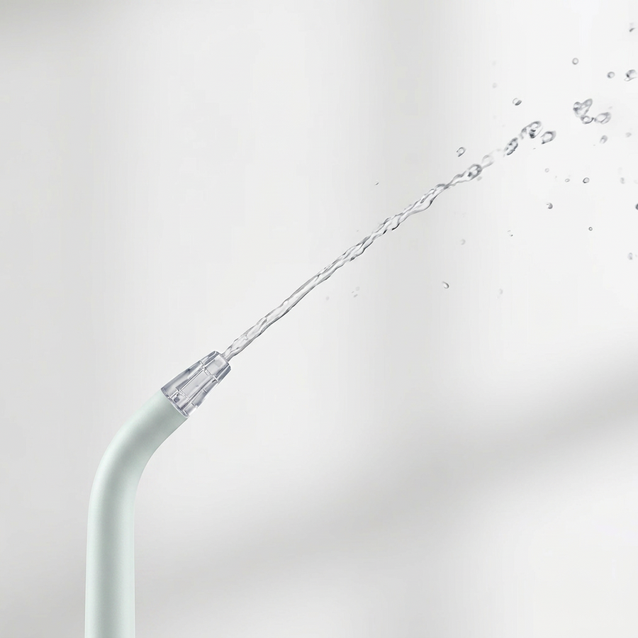 Close-up of a water flosser tip spraying a stream of water