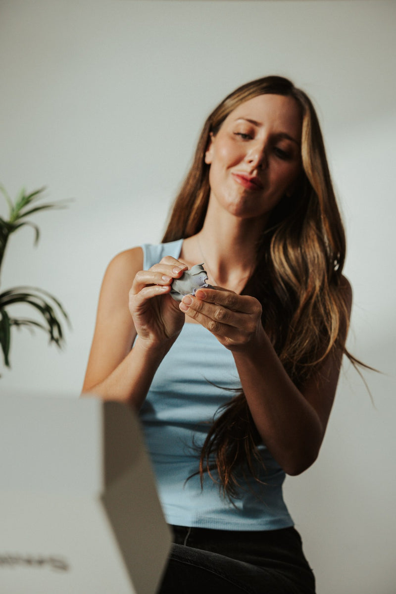 A woman holding her clear aligners