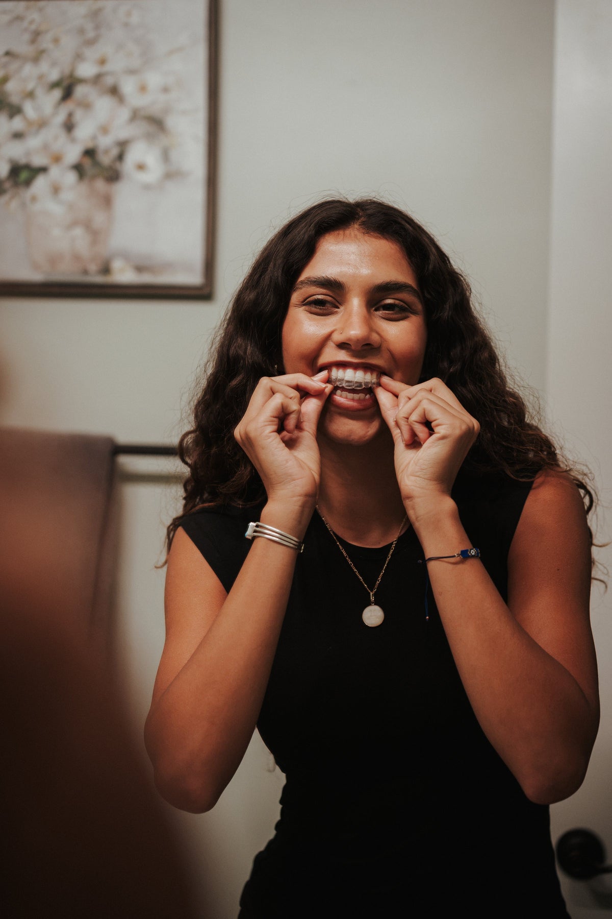 Smiling woman putting in her clear aligners