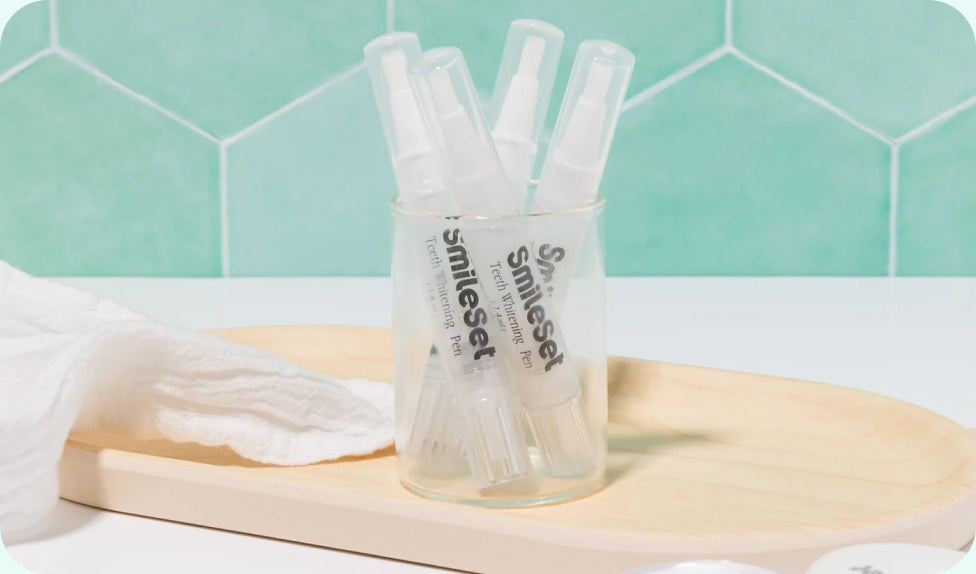 SmileSet whitening gel pens in a glass