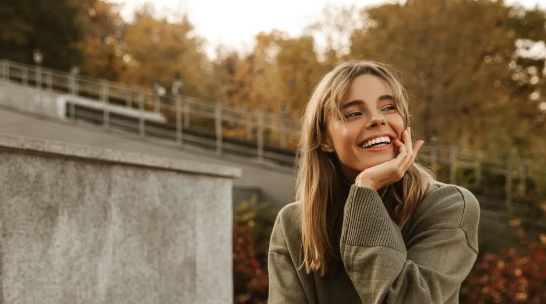 Woman smiling outdoors wearing clear aligners